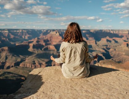 woman meditating on the rocks slow travel